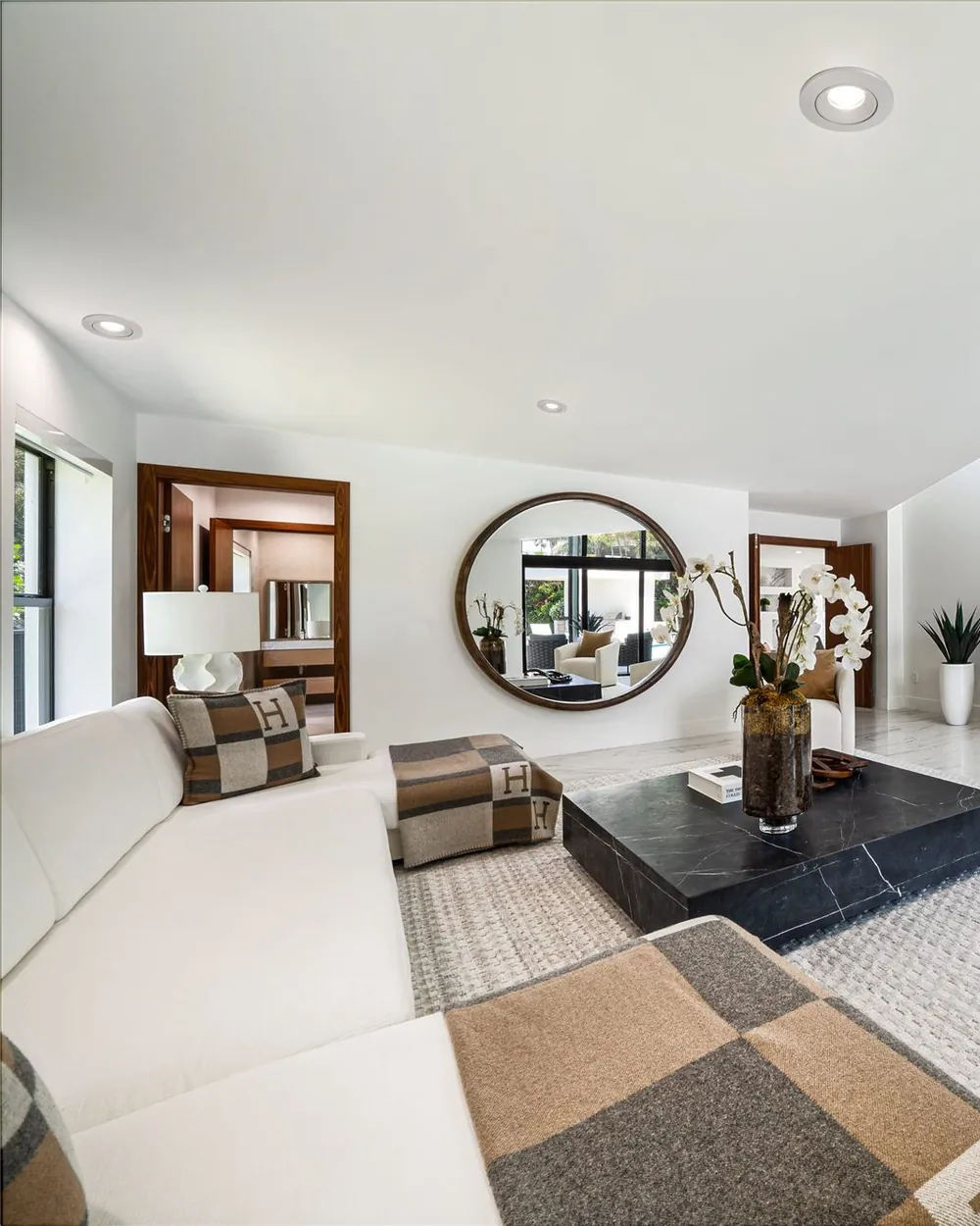 A minimalist living room in soft neutral tones with natural light and elegant furnishings